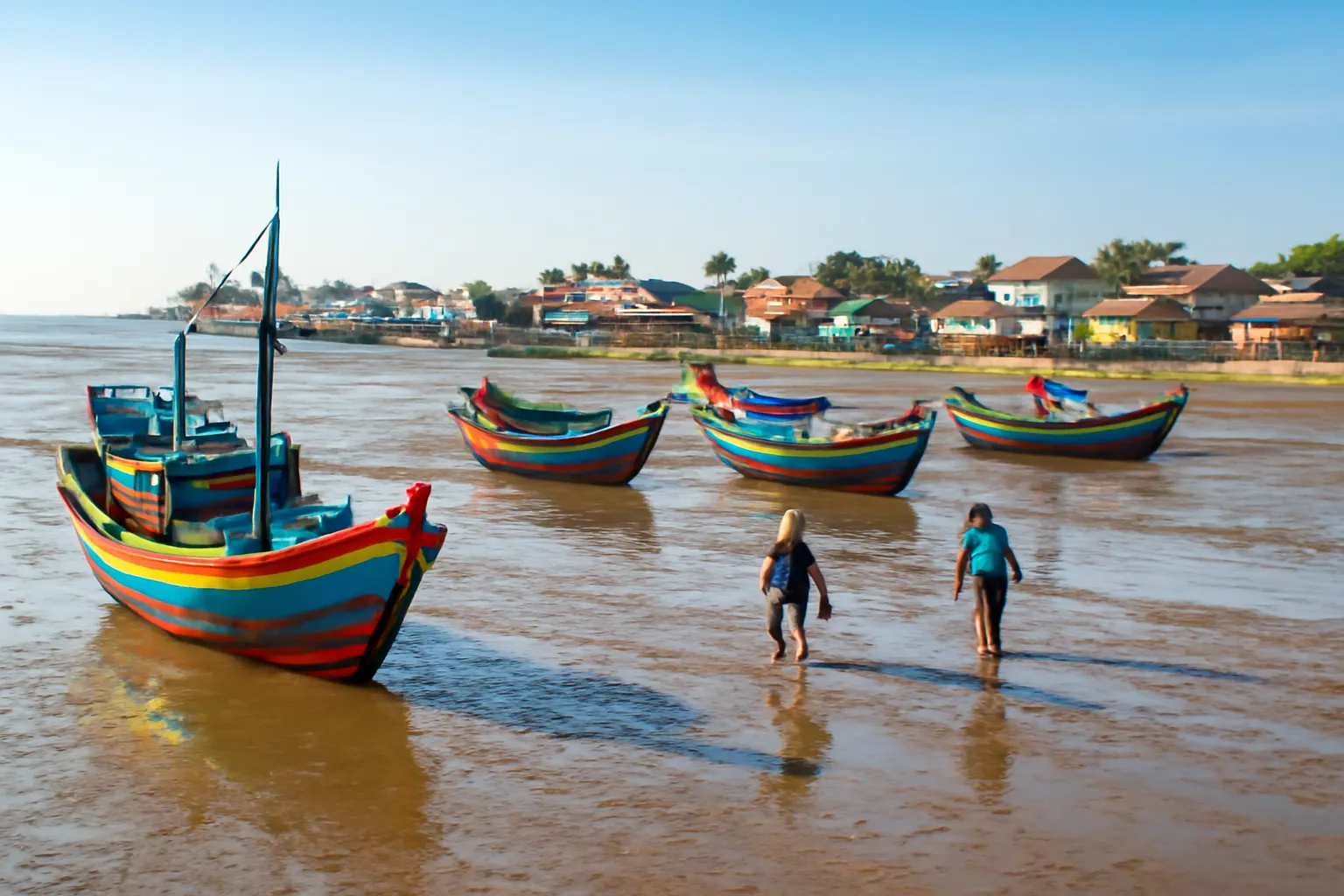 Thuyền đánh cá nằm trên bãi bùn khi nước ròng ở làng chài